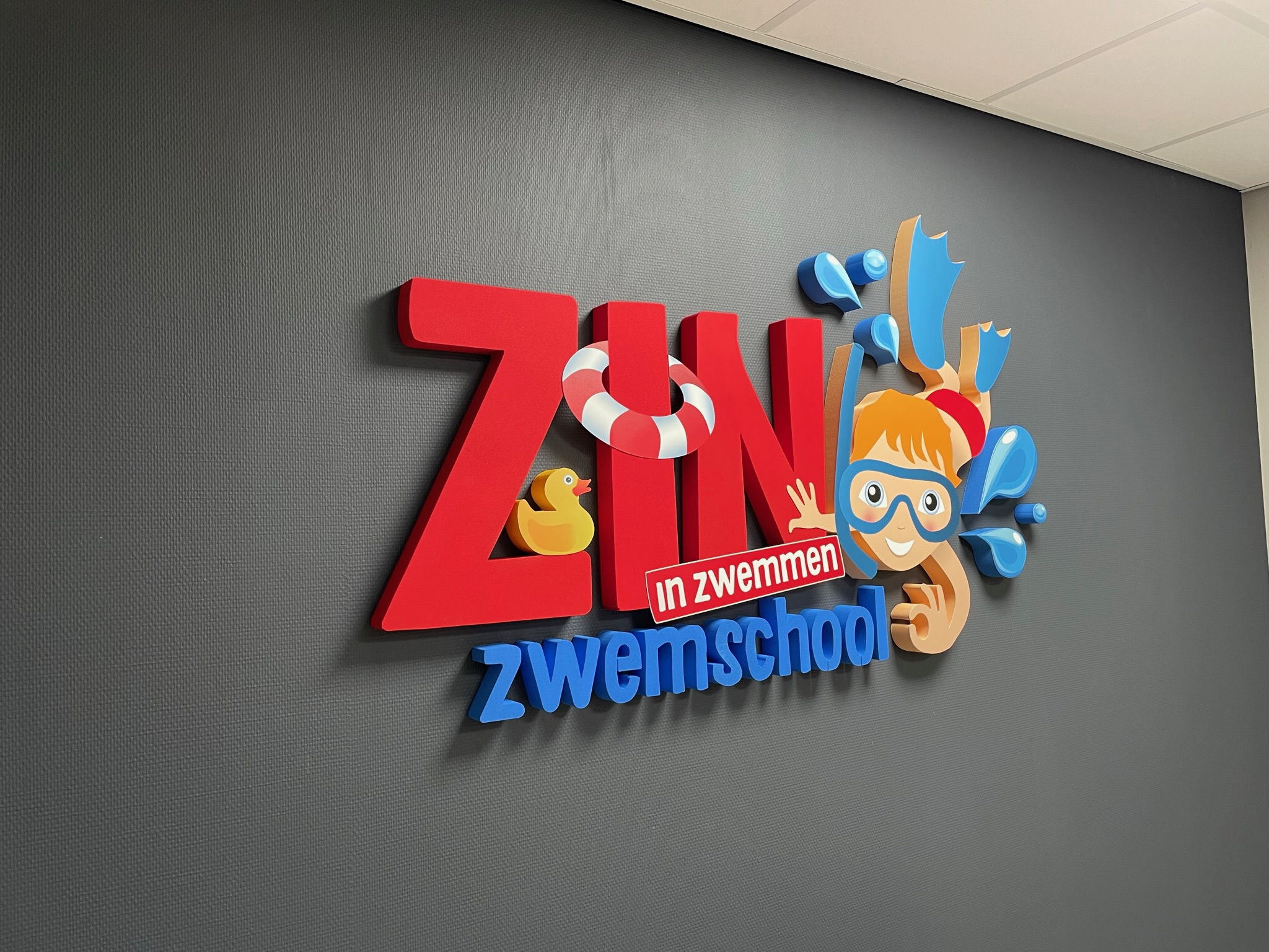 Piepschuim logo op de muur voor Zin in Zwemmen