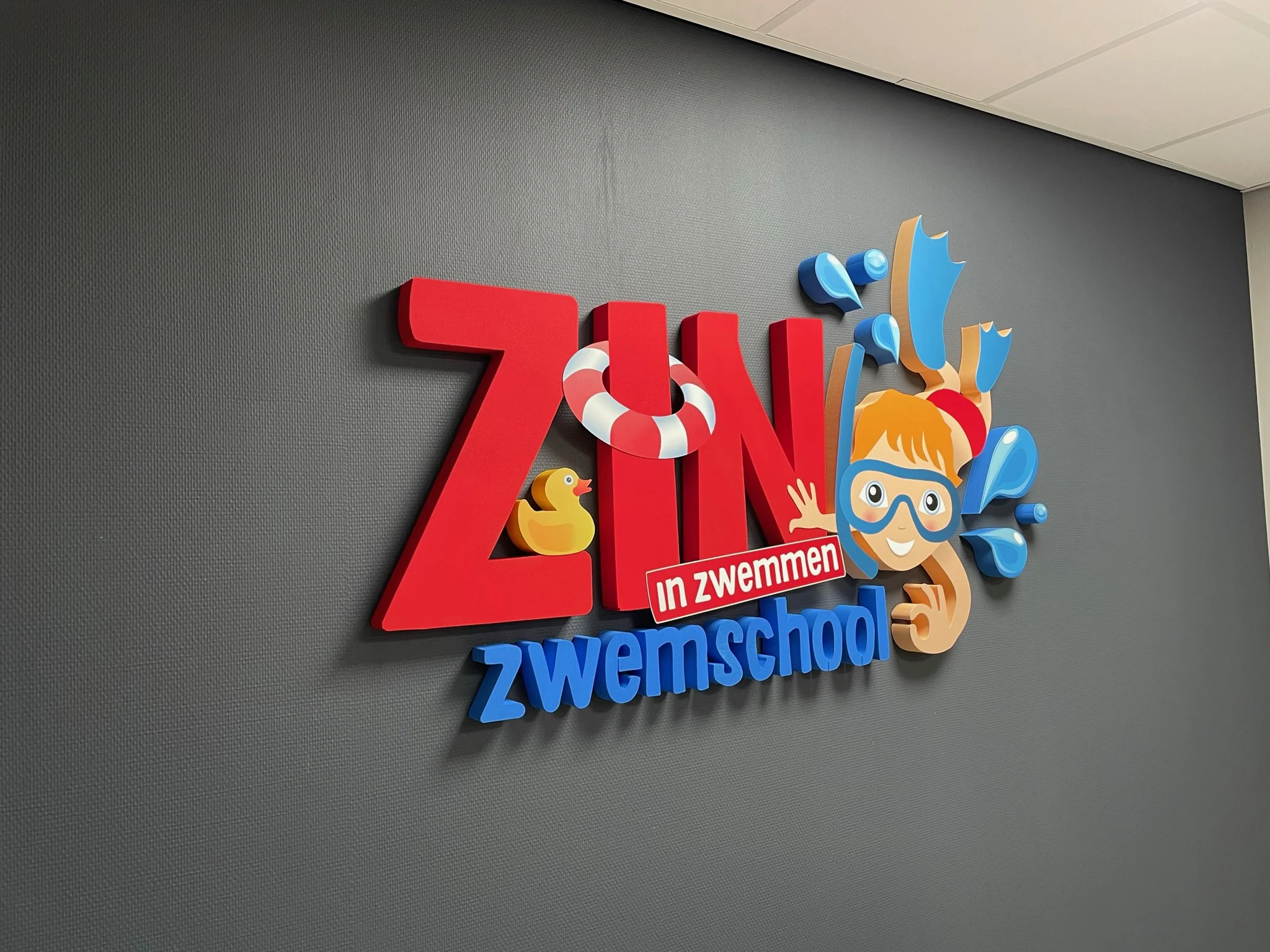 Piepschuim logo op de muur voor Zin in Zwemmen